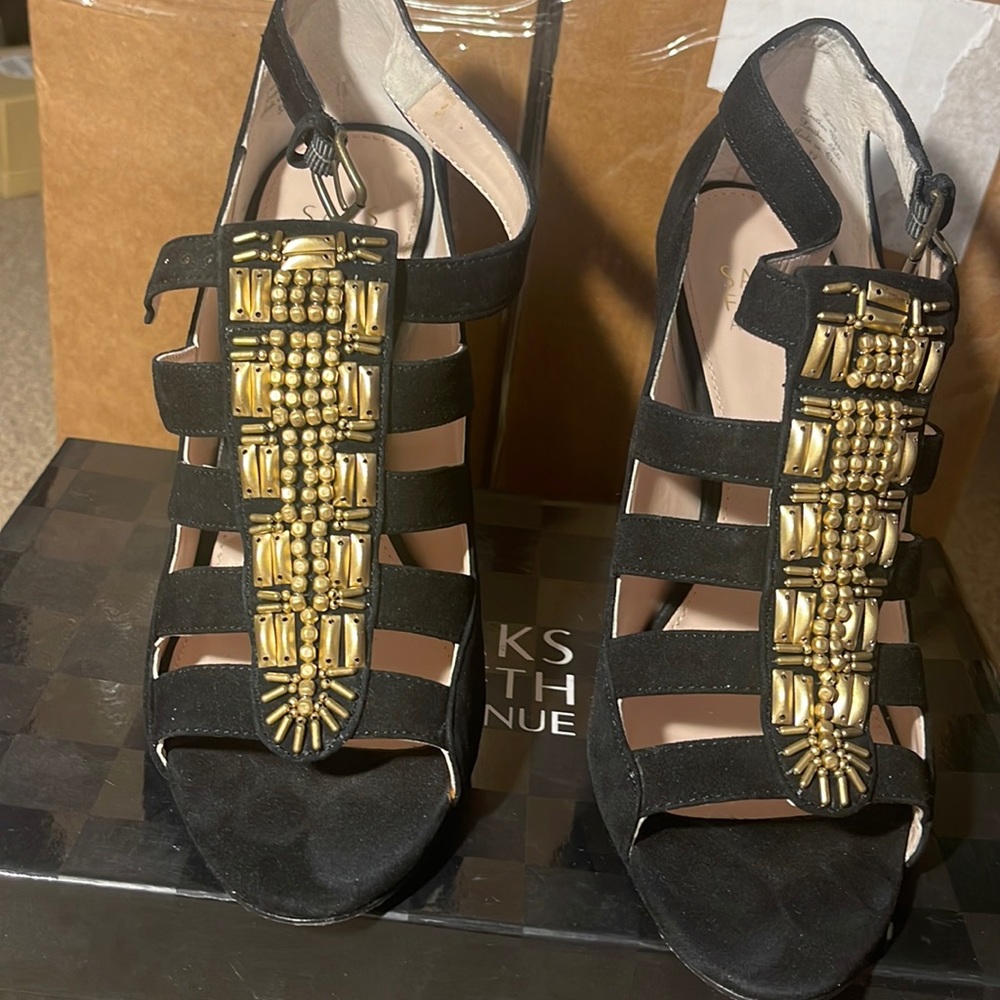 Black suede open toe pump with gold embroidery in the front.